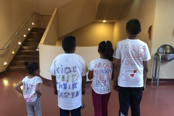 Kids showing writing on the back of their shirts
