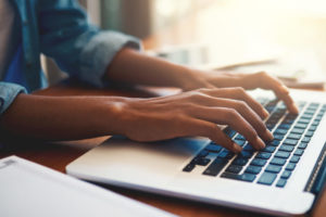 This image is of a person using a laptop computer to complete their 2020 Census