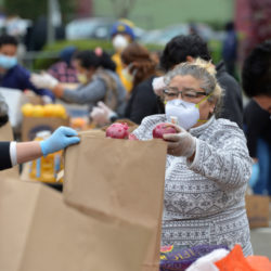 Volunteer Anita Hernandez of San Rafael and others prepare bags of food to give away during a community food distribution event