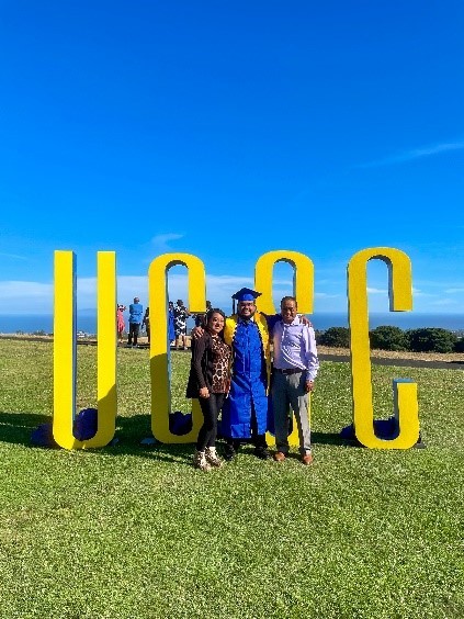 Jordan Vasquez and his parents stand inf ront of UCSC sign 